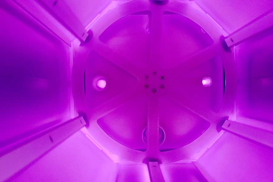 Inside vacuum plasma chamber with uniform purple glow for advanced surface treatment and thin film coating processes